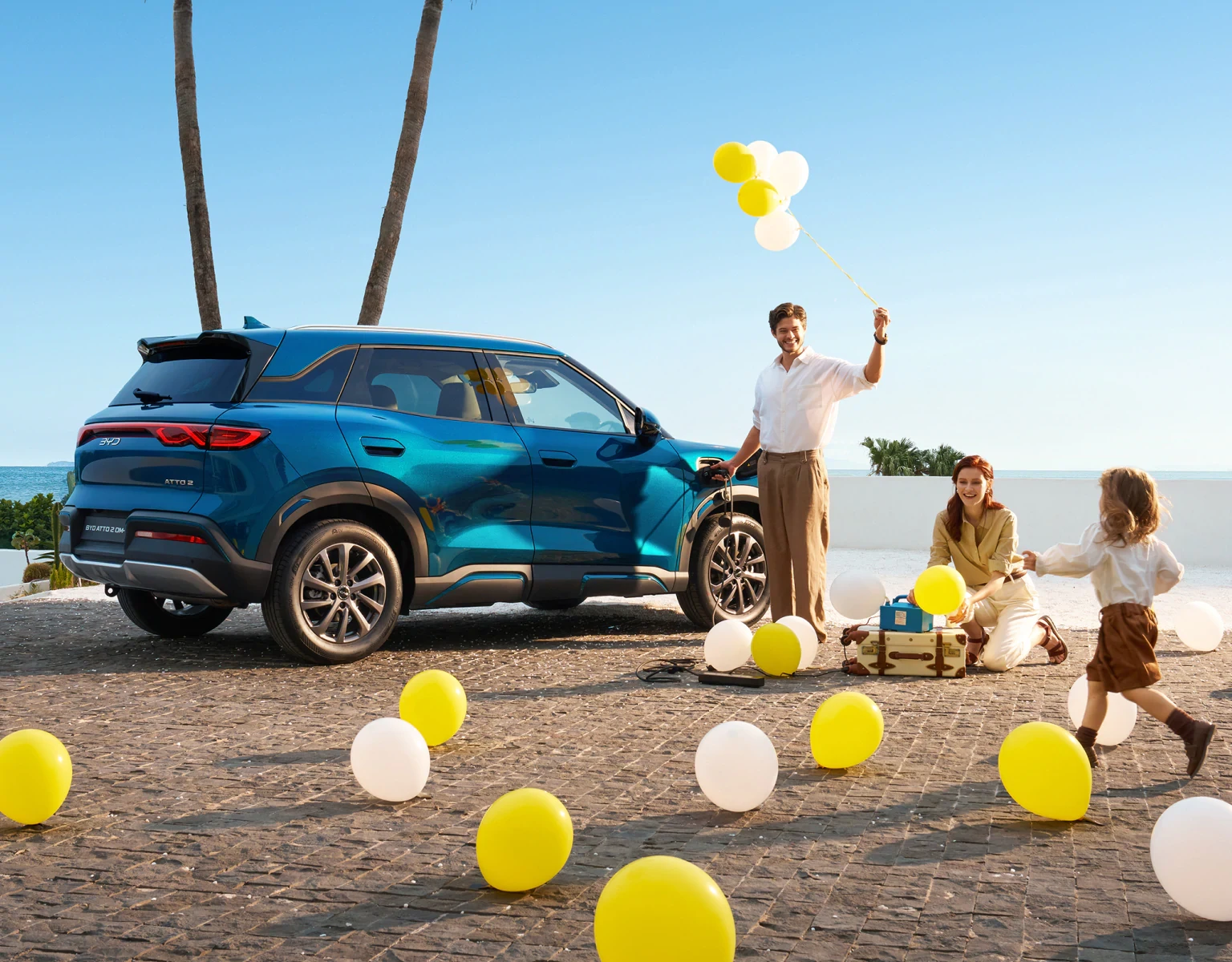 BYD ATTO 2 DM-i töltése közben a család lufikkal játszik